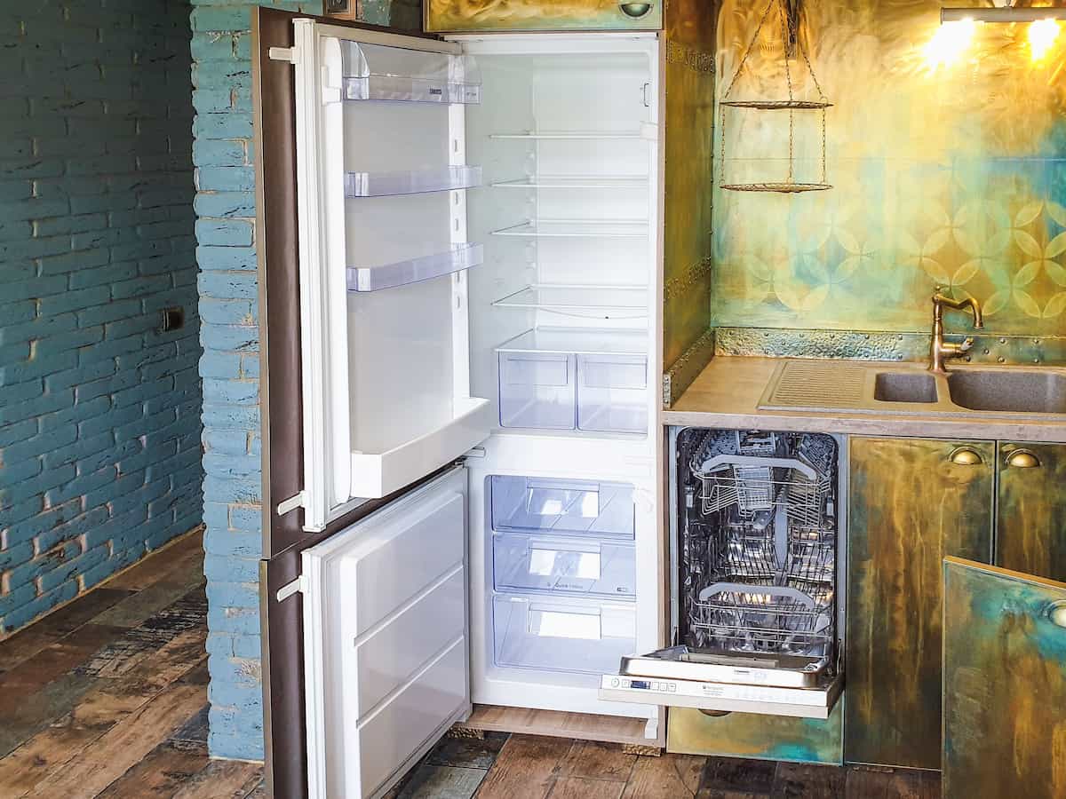 Technician diagnosing an open refrigerator with tools
