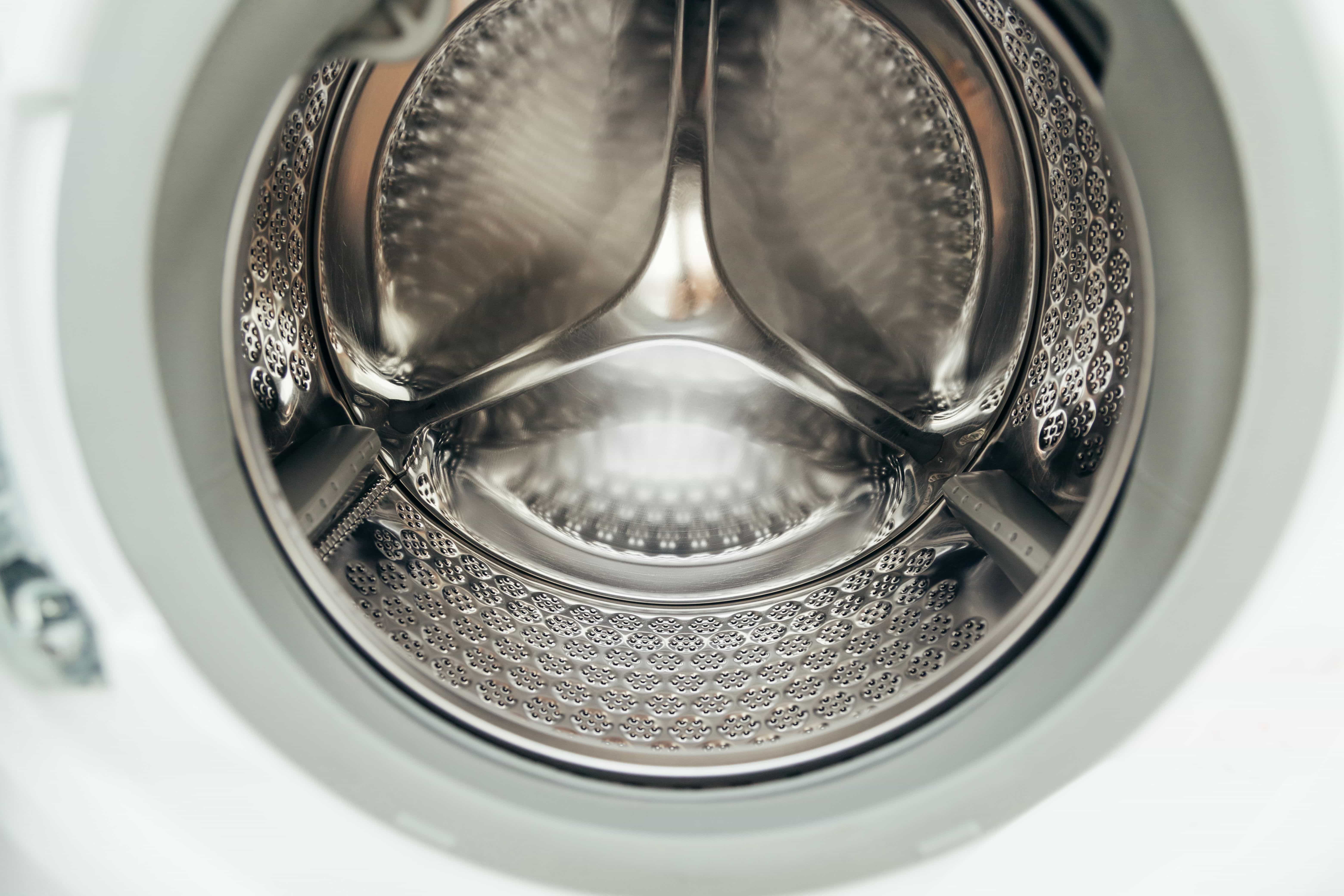 Open washing machine drum being inspected during repair